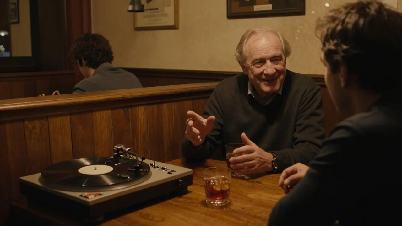 Cozy bar interior with wooden booths and vinyl records, owner chatting warmly with a visitor under dim amber lighting.