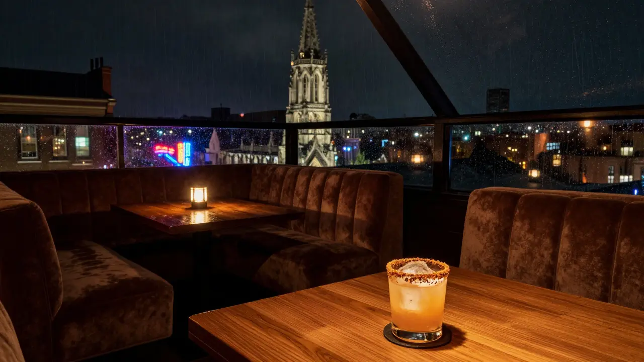Intimate rooftop bar with moody lighting and a single cocktail, framed by Soho's neon signs and rain.